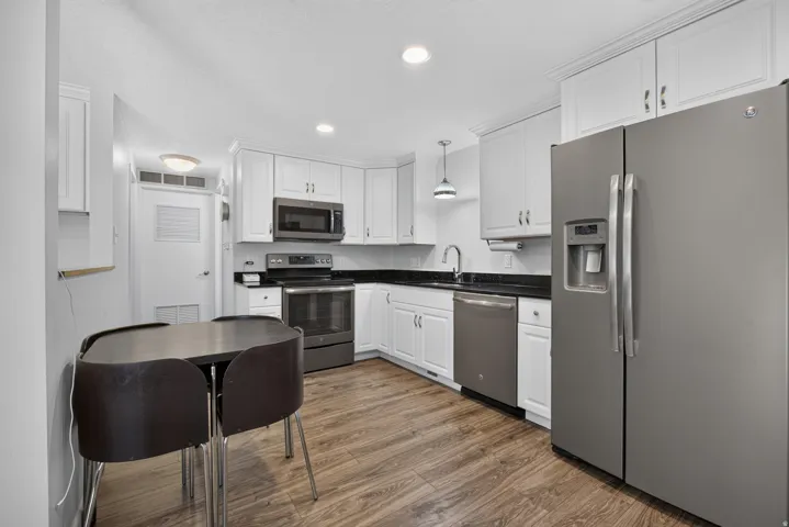Updated kitchen with shaker style cabinets, stainless steel appliances, can lighting, quartz countertops and plenty of storage.