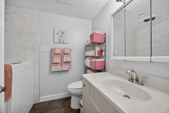 Spacious bathroom with walk-in tub. tub has shower wand, and tile surround and can be used as a shower.