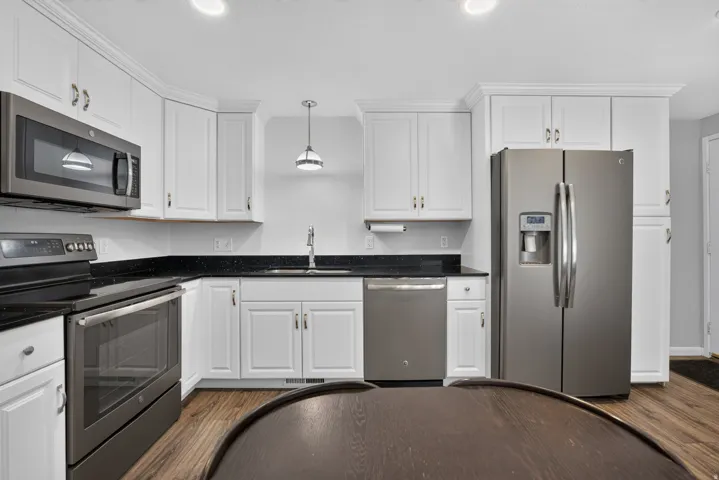 Updated kitchen with shaker style cabinets, stainless steel appliances, can lighting, quartz countertops and plenty of storage.
