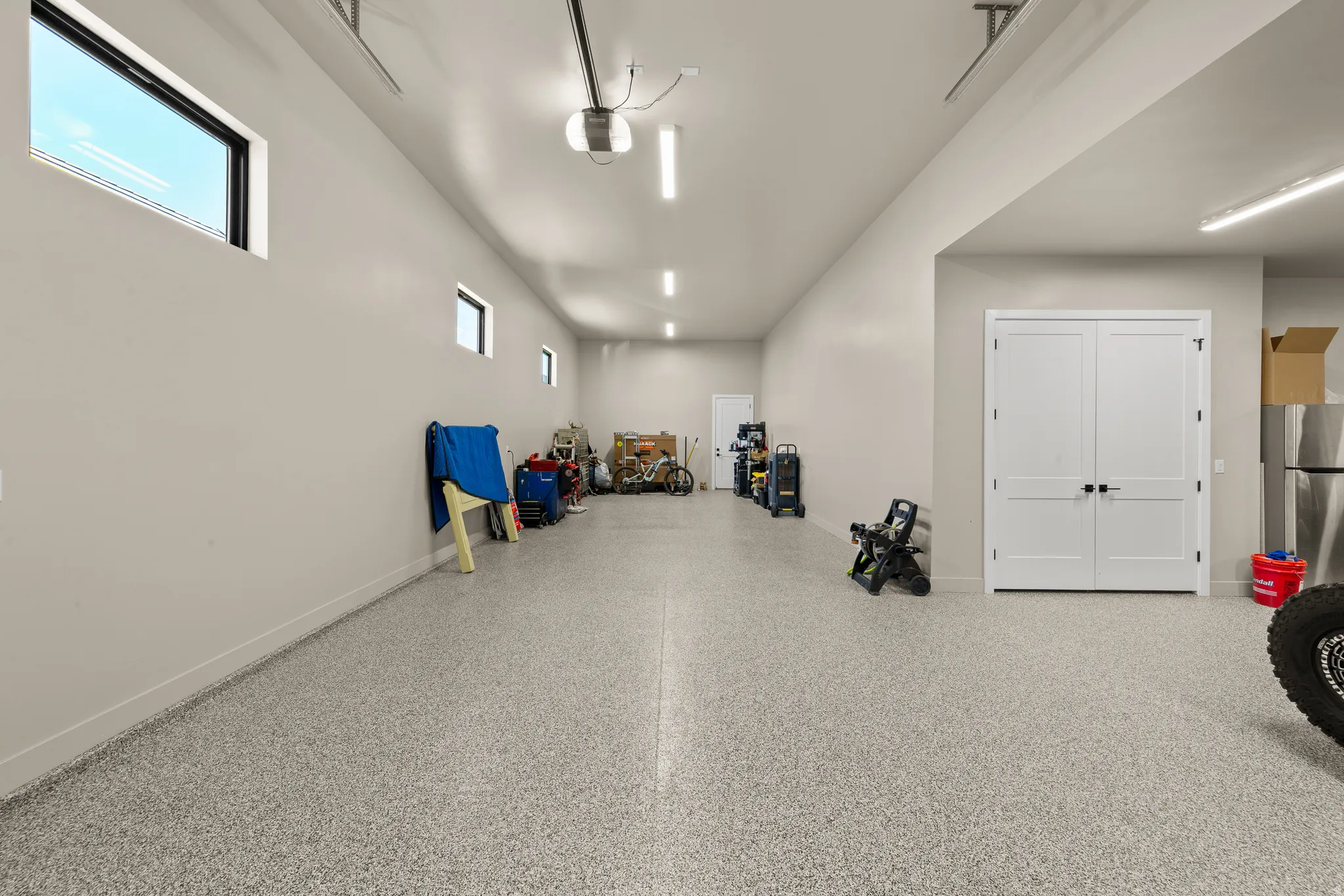 Expansive garage with an epoxy floor finish, multiple windows, and recessed lighting