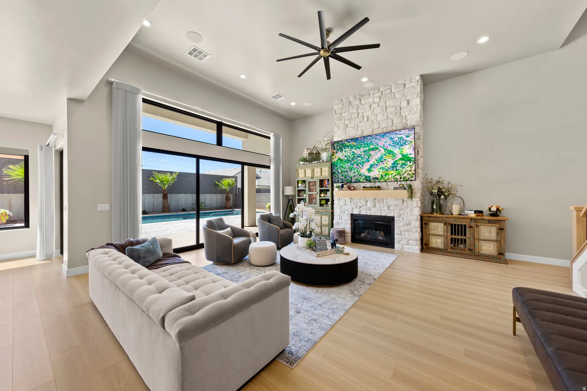 Living area featuring wood-finish flooring, a stone fireplace with a built-in firebox, and a large sliding glass door