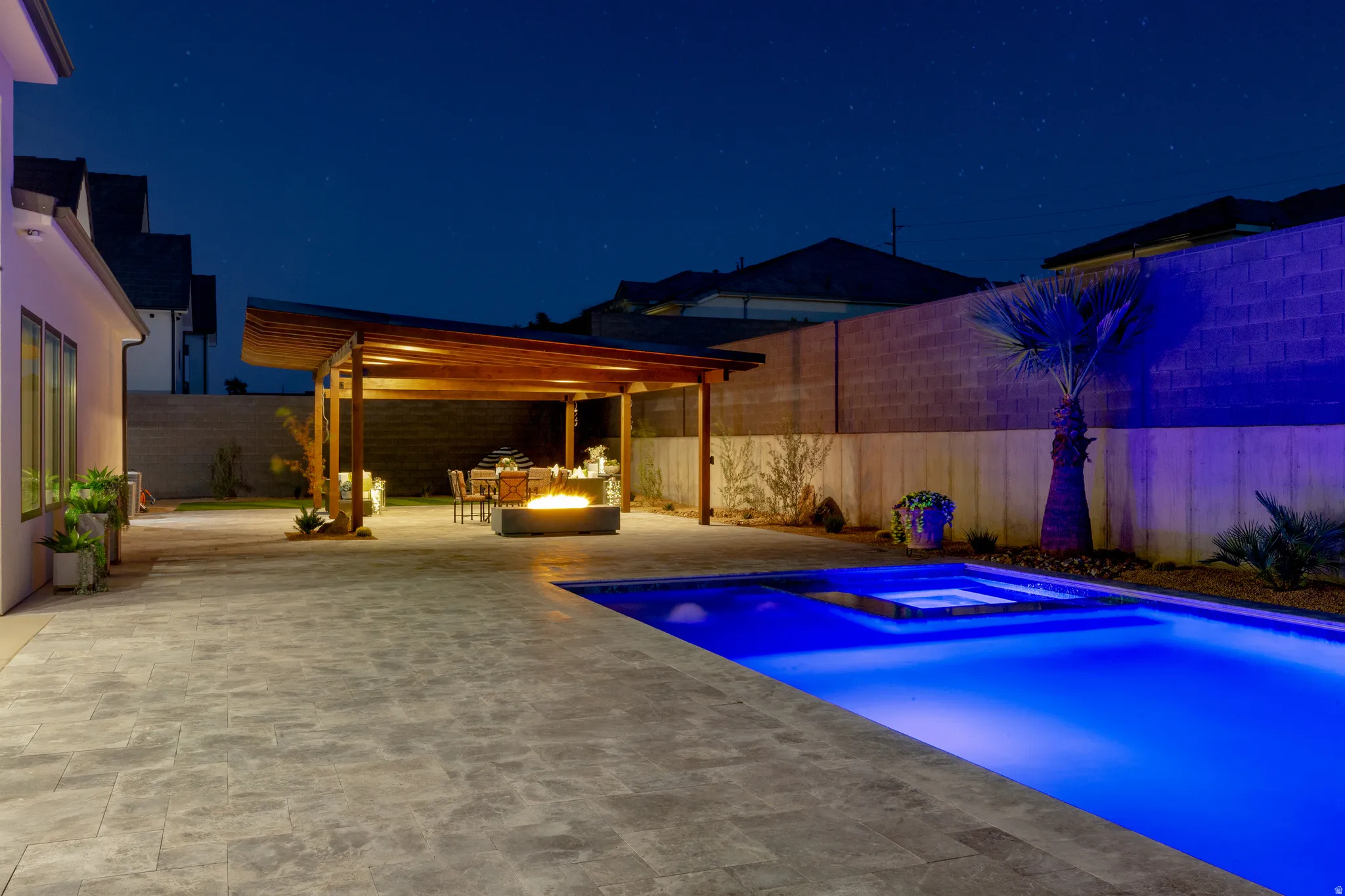 Expansive paver patio with a built-in pool and integrated spa