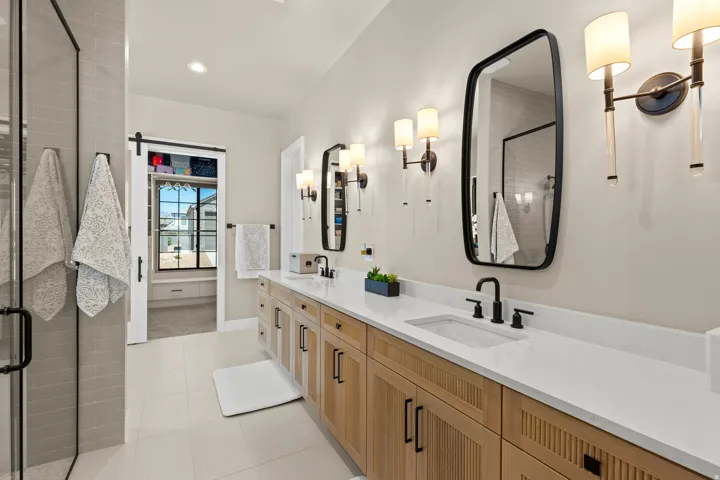 Dual vanity with wood-finish cabinetry, white countertop, and integrated sinks