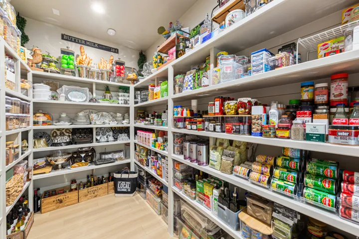 Generous walk-in pantry with extensive built-in shelving, providing ample storage