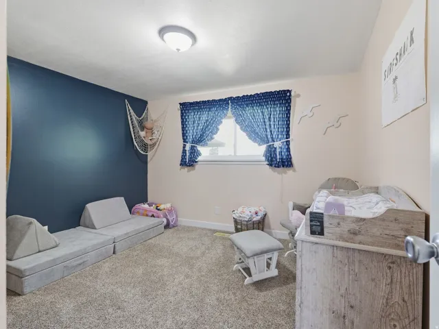 Guest bedroom with light gray walls, two windows, and a flush-mount ceiling light fixture