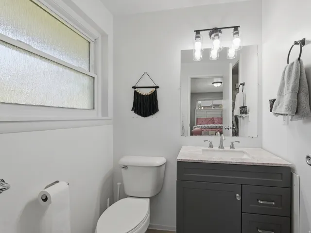 Master en-suite bathroom with vanity with a light-colored countertop, undermount sink, and dark gray cabinetry