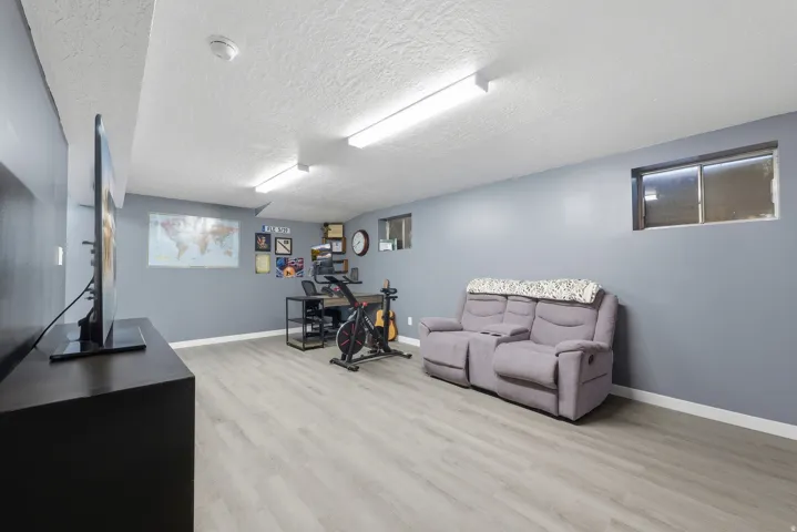 Recessed windows, light grey wall paint, wood-finish flooring, and overhead strip lighting