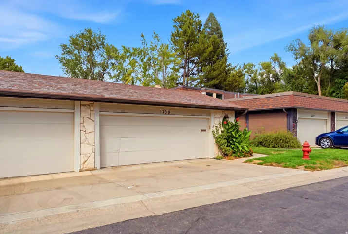 Two-car garage with light-colored doors and stone veneer accents