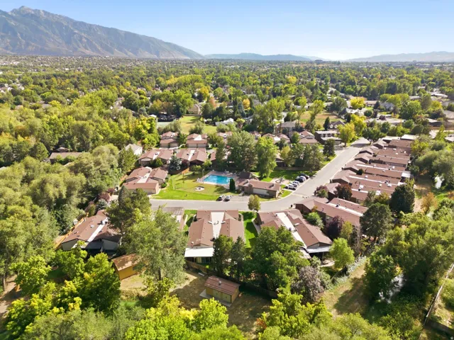 Community featuring a swimming pool, mature trees, and mountain scenery