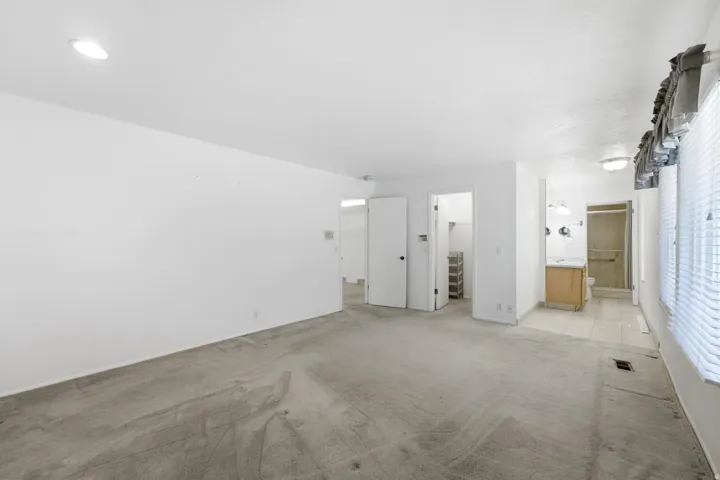 Recessed ceiling lighting, durable carpeting, interior doors, vanity with integrated sink, and a shower enclosure with a glass door