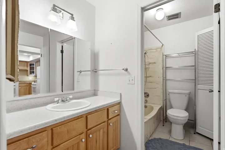 Bathroom featuring a vanity with wood-finish cabinetry, a white countertop, and an integrated sink with a chrome faucet