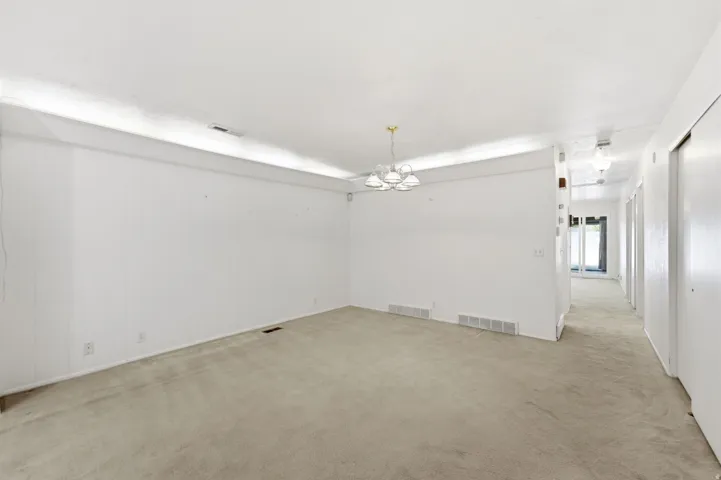 Carpeted flooring throughout, recessed lighting, and a multi-bulb chandelier