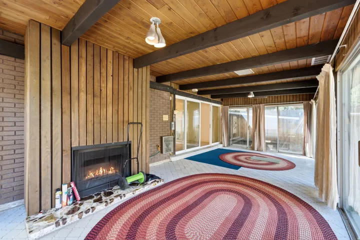 Exposed wood beam ceiling with wood paneling and recessed lighting