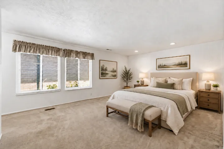 Spacious room featuring neutral carpeting, recessed lighting, and dual windows