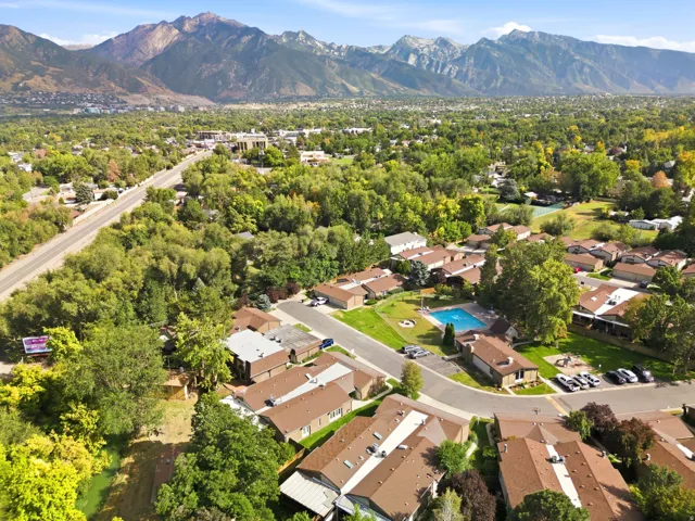 Community featuring a swimming pool, surrounding green spaces, and mature trees