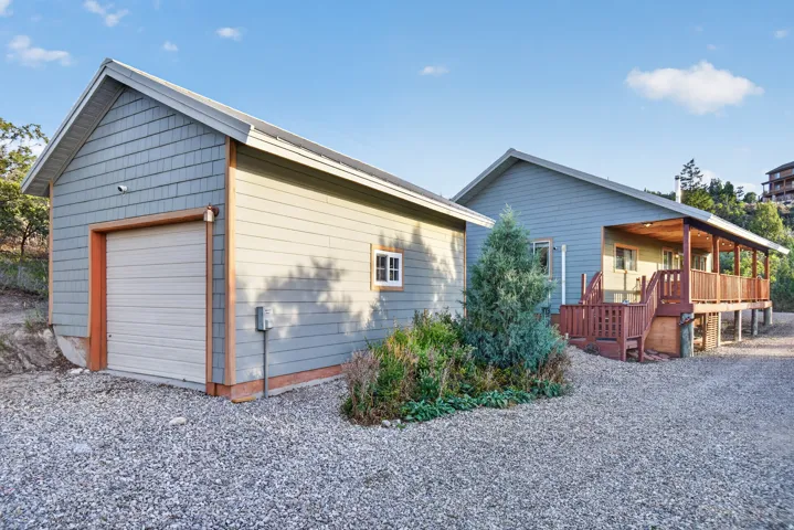 Detached garage with horizontal siding, a single garage door, and a dedicated entry door