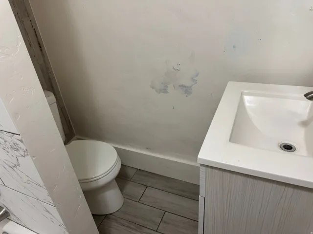 Vanity with integrated sink, wood-finish cabinetry, and tiled flooring