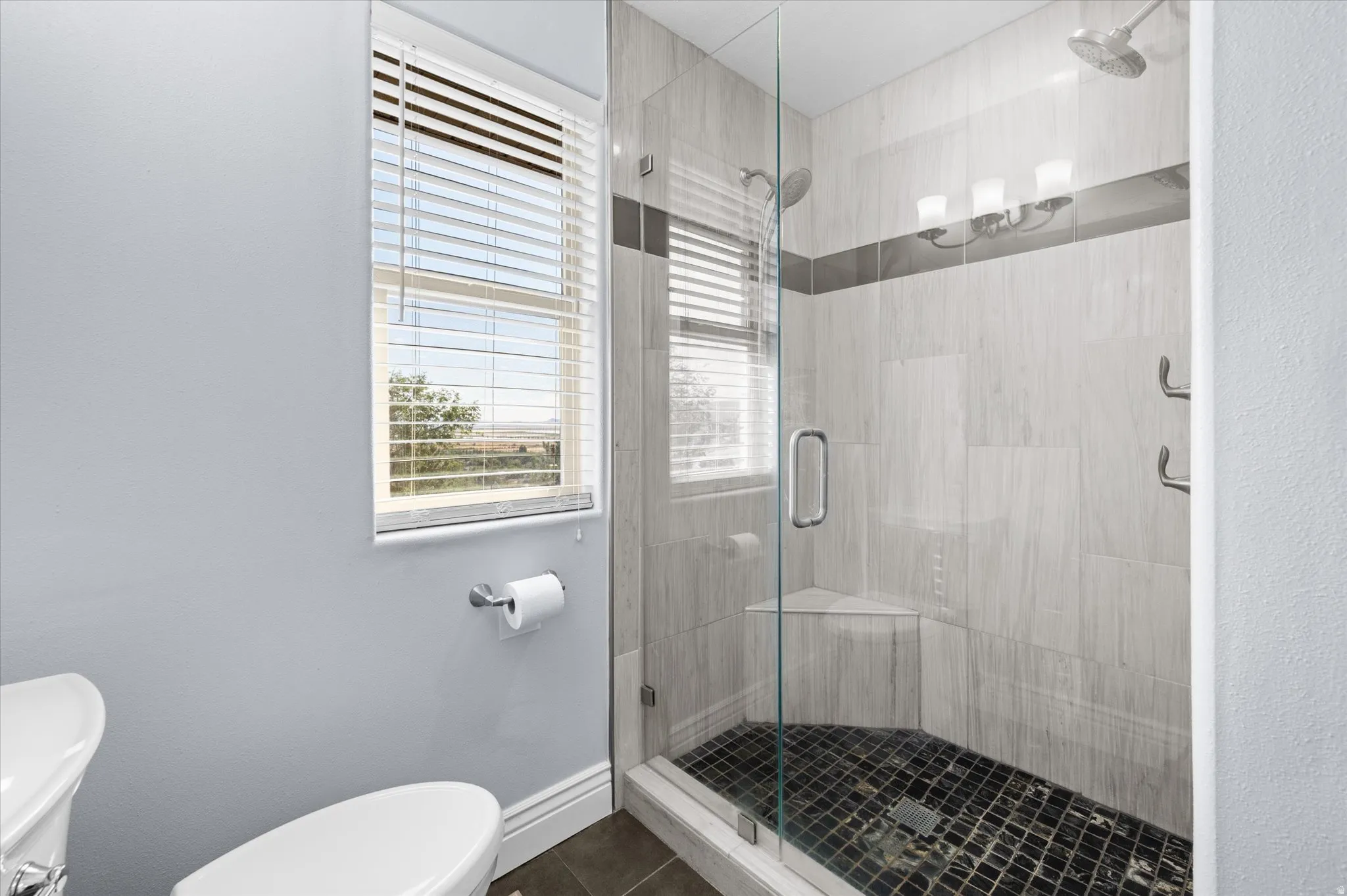 Primary Bathroom with updated marble shower and beautiful French glass door.