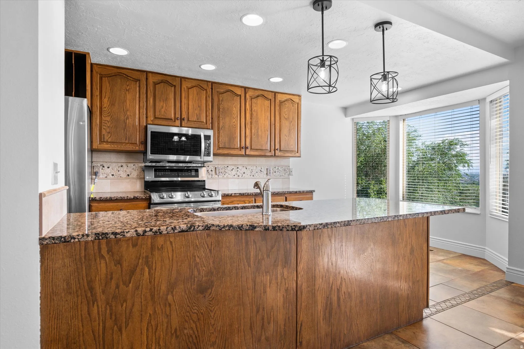 Kitchen w/breakfast nook and semi-formal dining and fireplace.