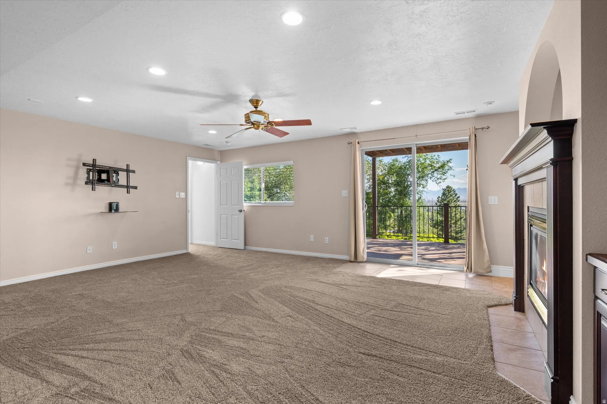 Basement Family Room w/gas fireplace, custom bookshelf and cabinets, and exit to backyard/deck.