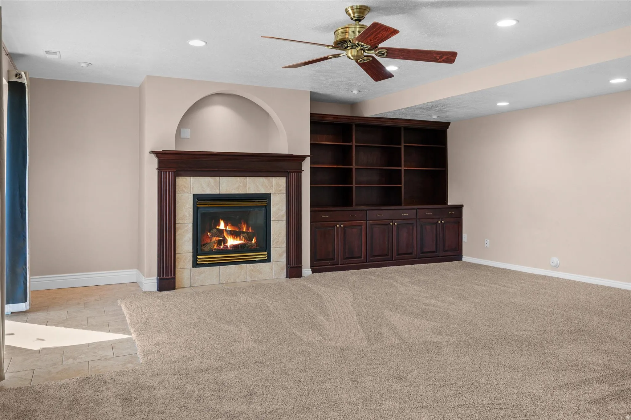 Basement Family Room w/gas fireplace, custom bookshelf and cabinets, and exit to backyard/deck.