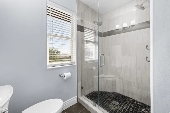 Primary Bathroom with updated marble shower and beautiful French glass door.