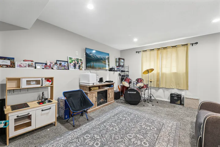 Recessed ceiling lighting, light gray wall paint, and gray carpet flooring