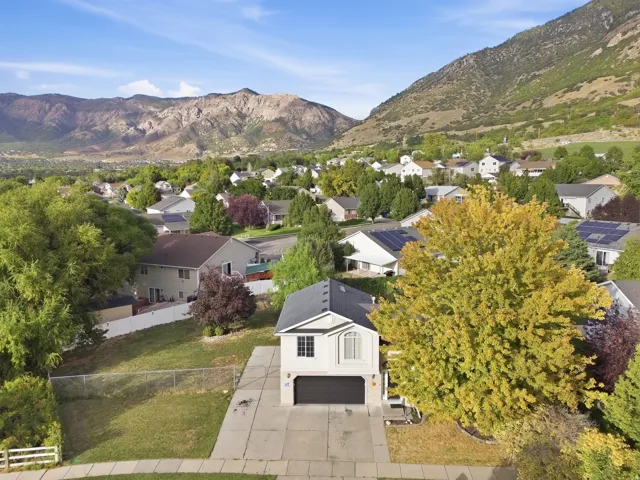 Charming residence situated on a manicured lawn with mature landscaping and mountain backdrop