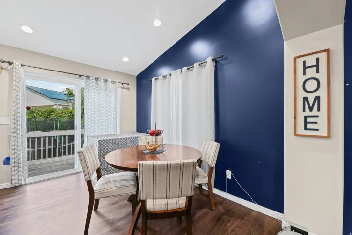 Wood-finish flooring, recessed lighting, sliding glass door, and a partially vaulted ceiling