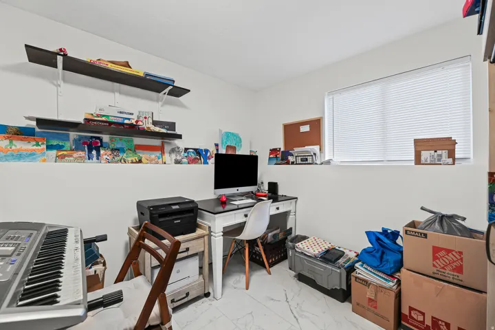 White walls, recessed window, white blinds, and built-in shelving
