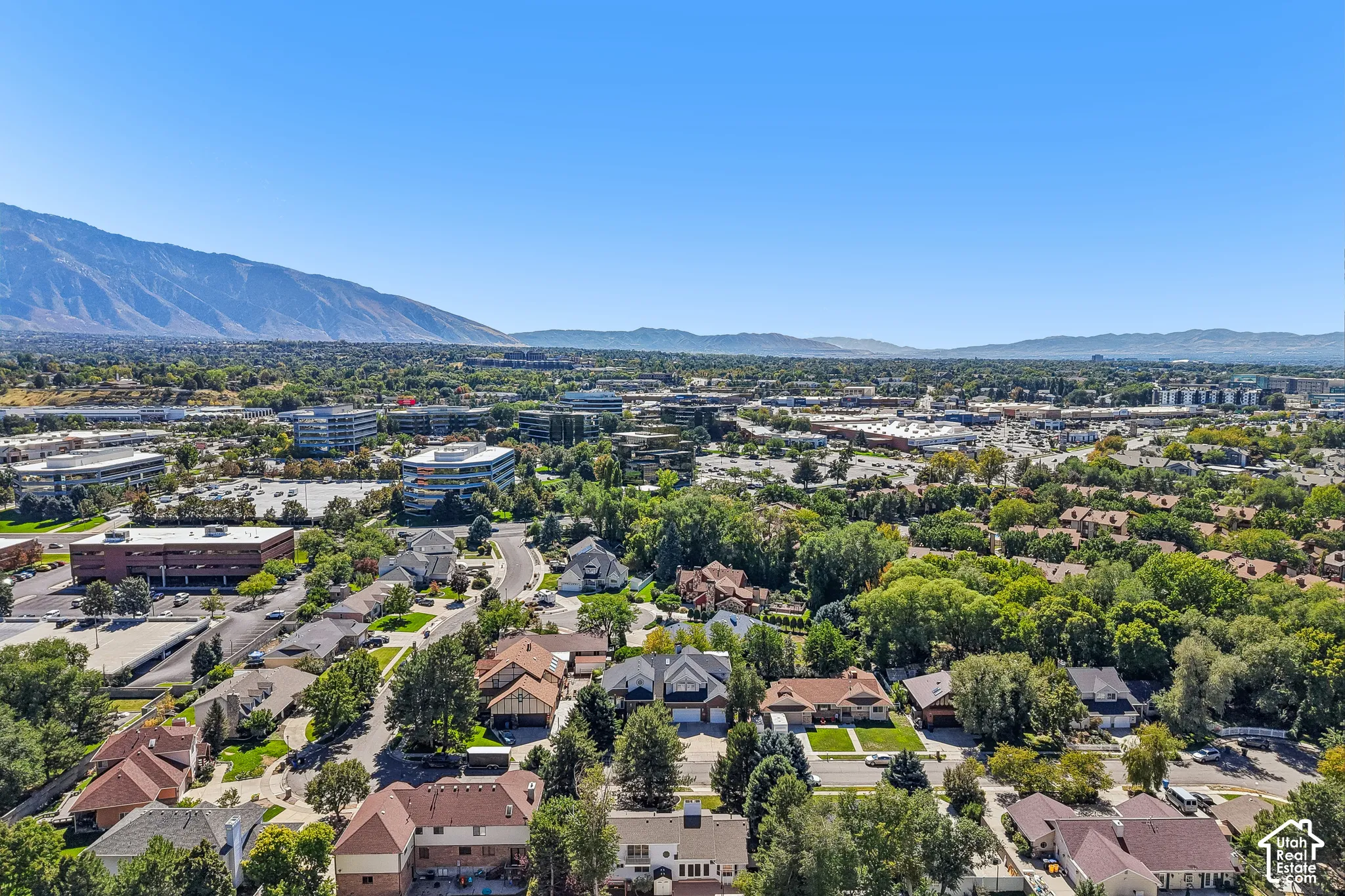 Residential area with surrounding commercial buildings and a prominent mountainous backdrop