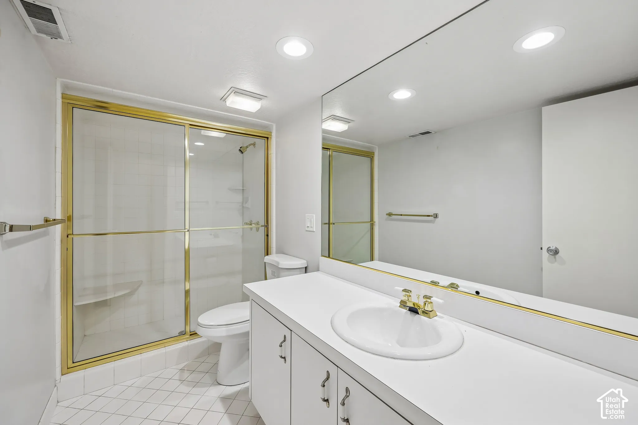 White vanity with integrated sink and gold-tone fixtures