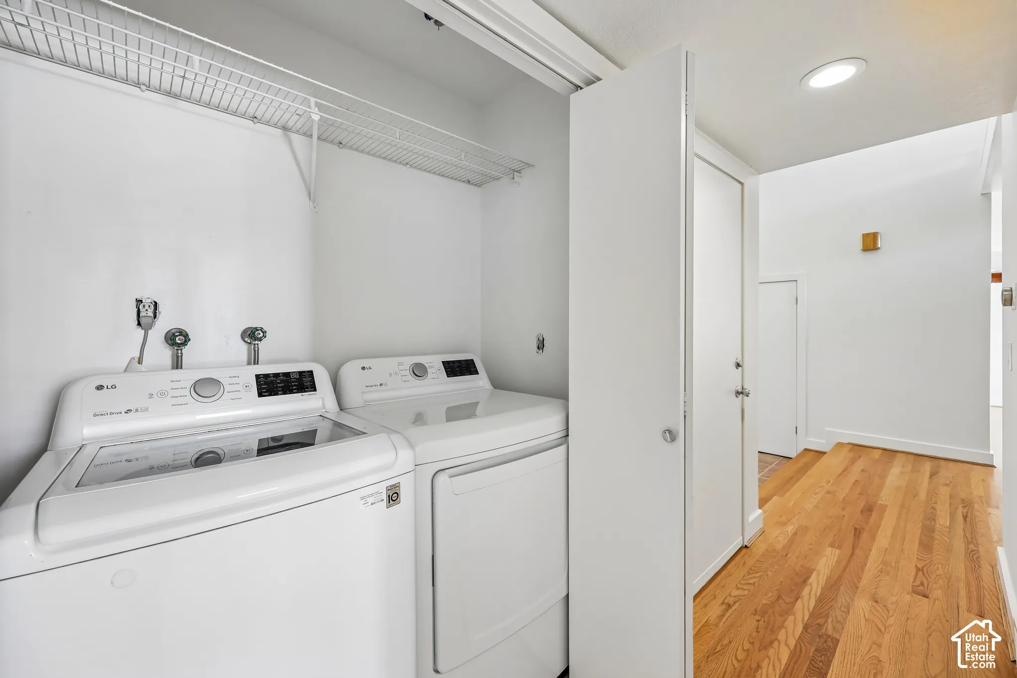 Dedicated laundry space featuring a white wire shelf, washer, and dryer