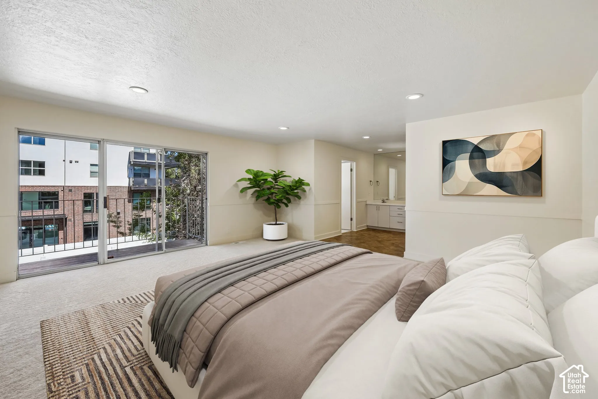 Recessed lighting, wood-finish flooring, and a private balcony with metal railings