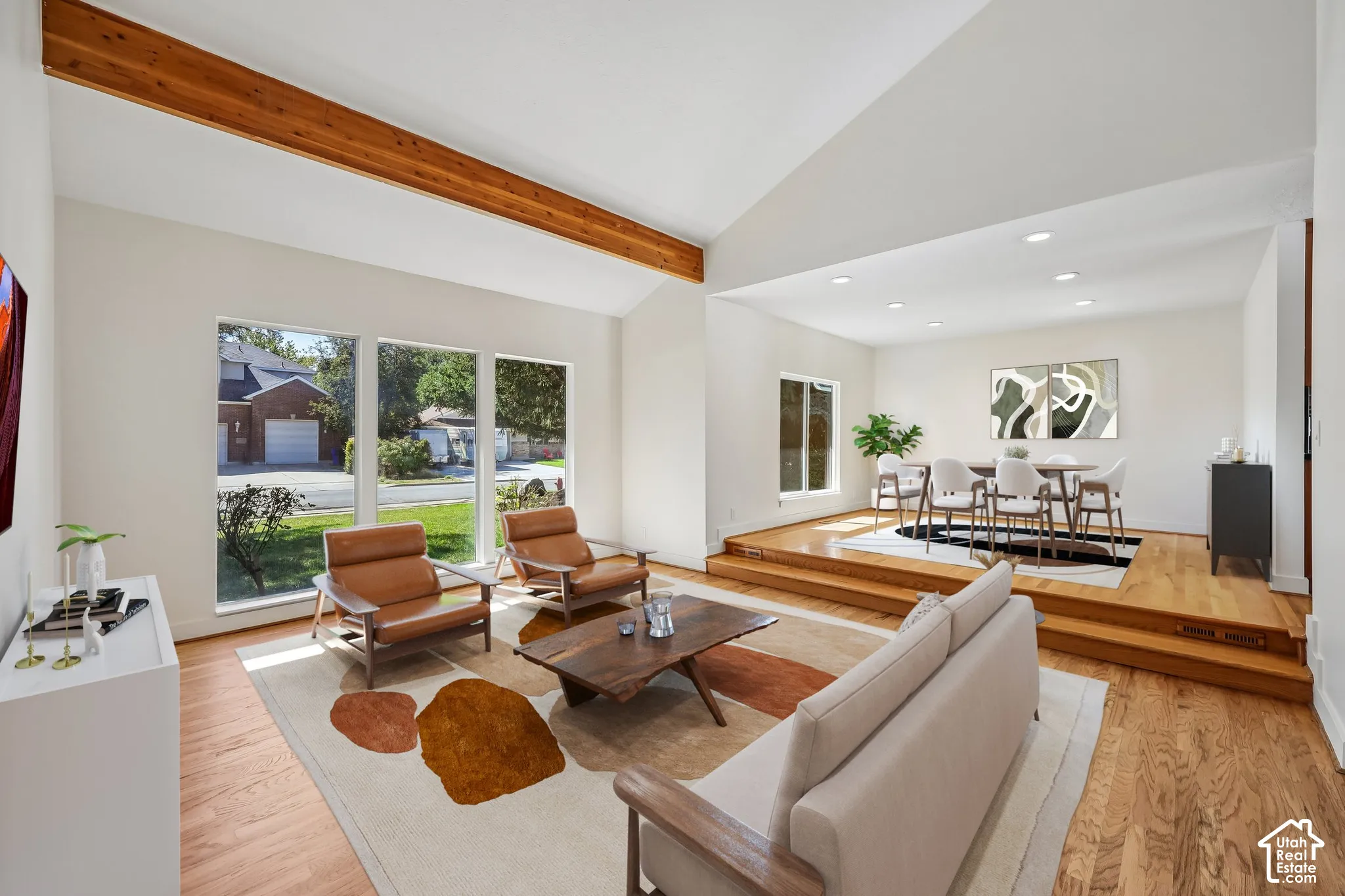 Vaulted ceiling with exposed wood beam, wood-finish flooring, recessed lighting, and large windows