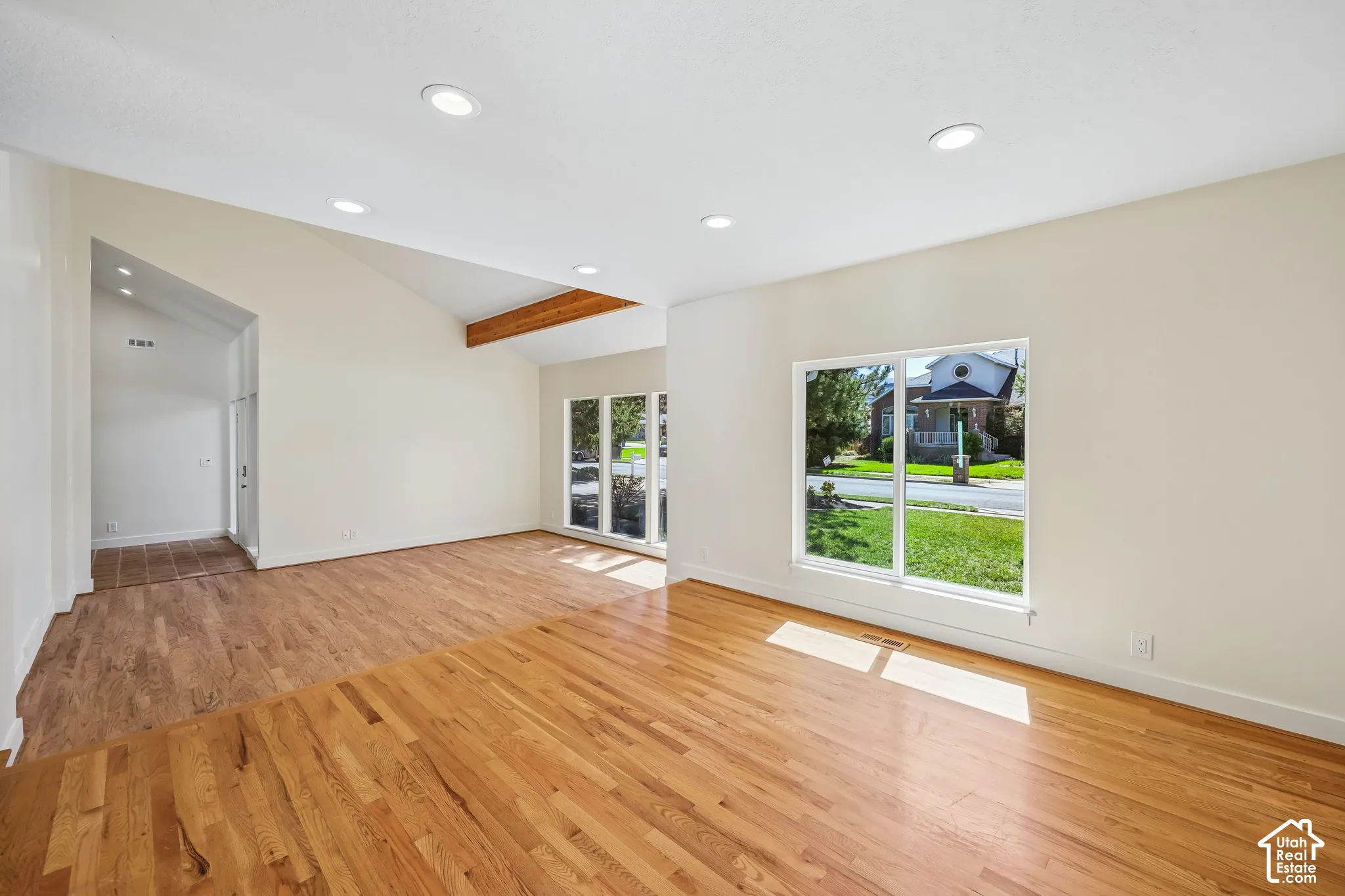 Hardwood flooring, recessed lighting, vaulted ceiling, exposed beam, and large picture windows