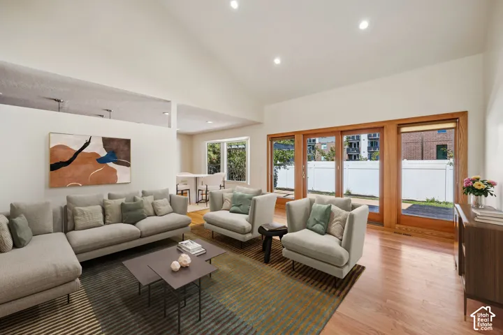 Vaulted ceiling, recessed lighting, wood-finish flooring, sliding glass doors, and an open-concept layout