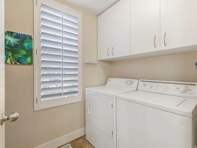 White plantation shutters, upper cabinetry with brushed nickel hardware, and wood-finish flooring