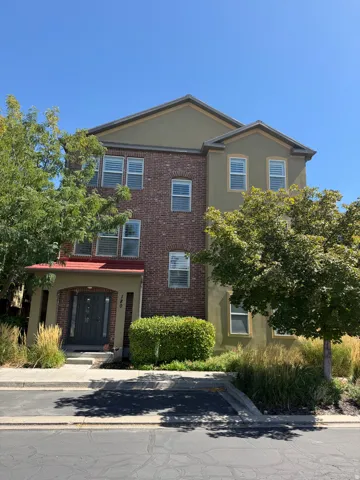 Three-story exterior featuring brick and stucco finishes