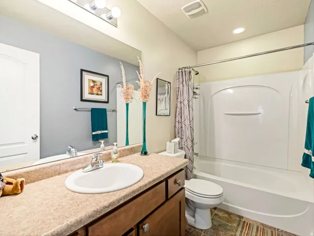 Vanity with integrated sink, wood-finish cabinetry, and laminate countertop