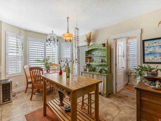 Tiled flooring throughout, bay windows with plantation shutters, recessed lighting, and a built-in display cabinet