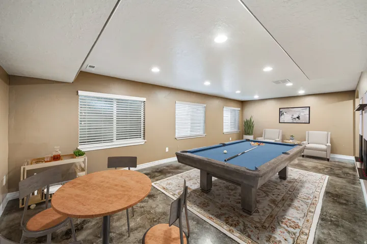 Recessed lighting, multiple windows with blinds, and durable flooring create a versatile space