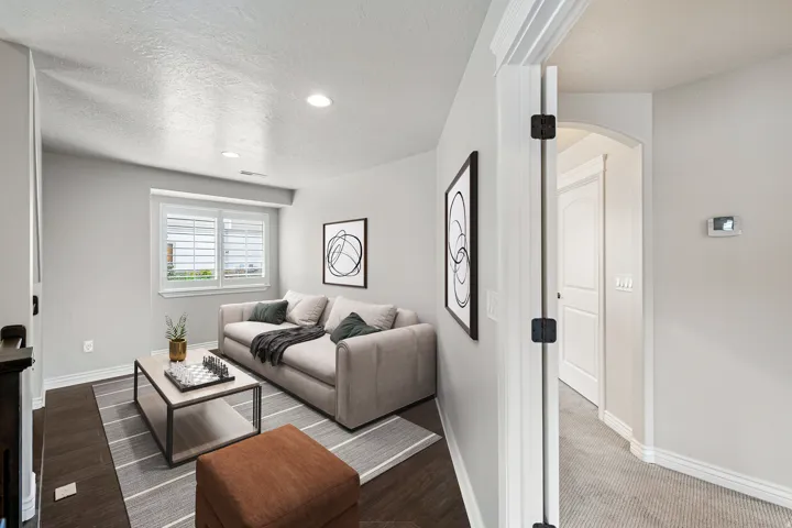 Recessed lighting illuminates this room featuring wood-finish flooring, a window with plantation shutters, and light-toned walls