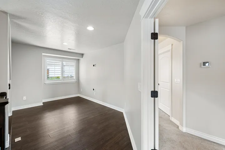 Recessed lighting illuminates wood-finish flooring