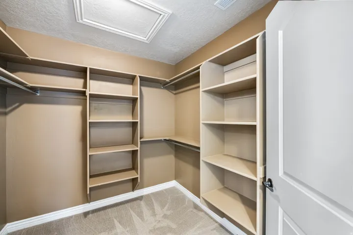 Custom shelving system, built-in storage, hanging rods, neutral wall color, recessed ceiling light
