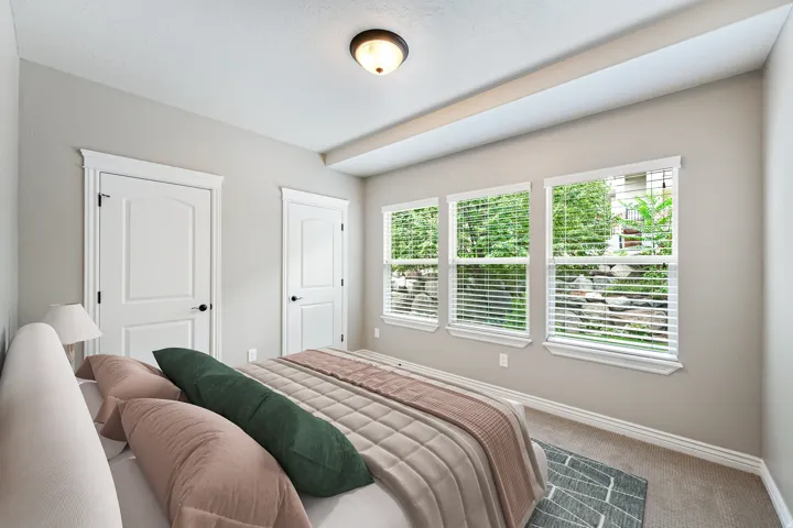 Three large windows featuring white blinds, two paneled doors with black hardware, recessed ceiling with a flush mount light fixture, and neutral wall paint