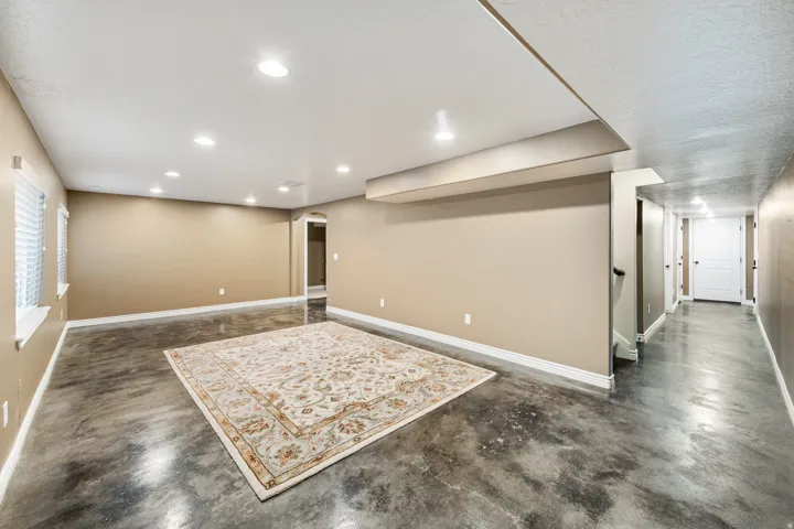 Recessed lighting, painted walls, polished concrete flooring, white trim, and interior doors