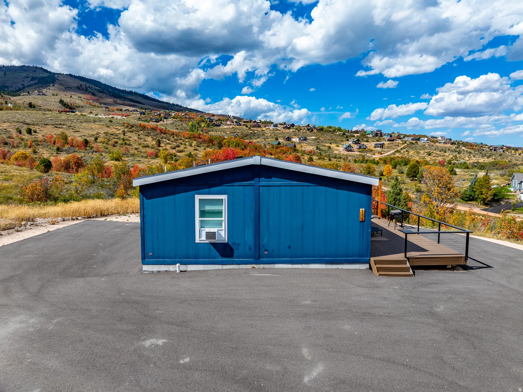 Blue exterior siding with a white-framed window, mountain view