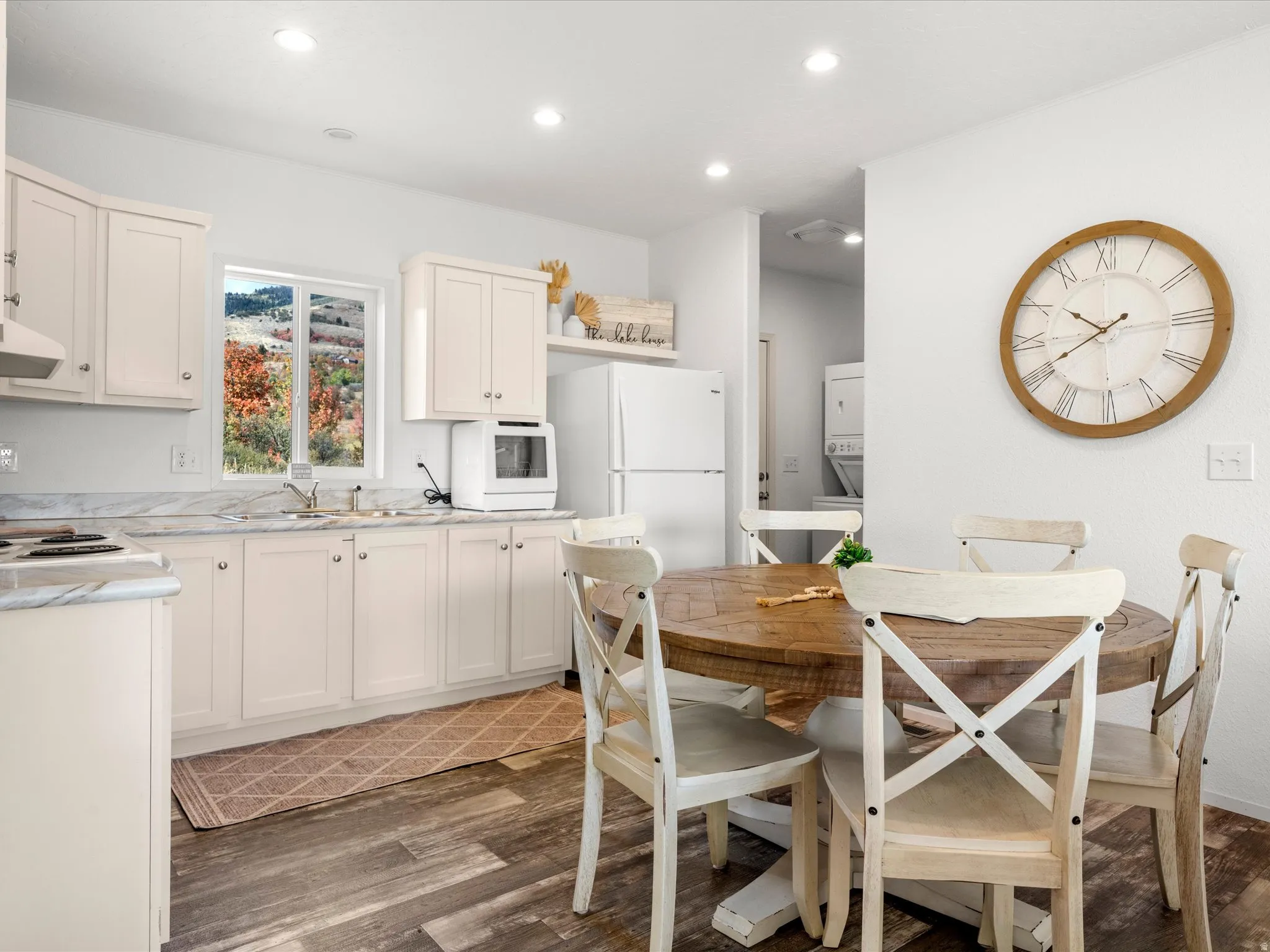Kitchen with wood-finish flooring, recessed lighting, white cabinetry, and light-toned countertops