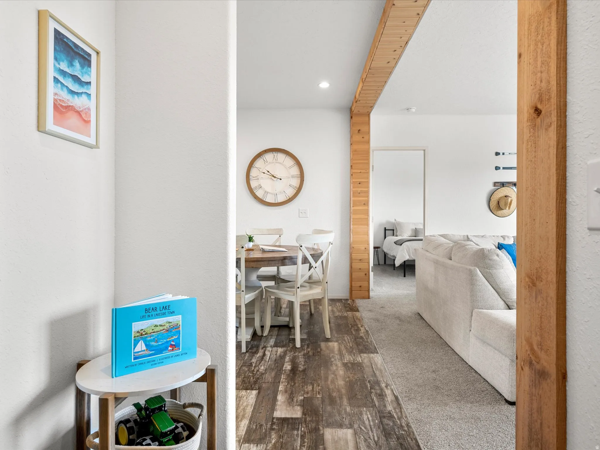Open-concept living space featuring wood-finish flooring, exposed wood beams, and recessed lighting